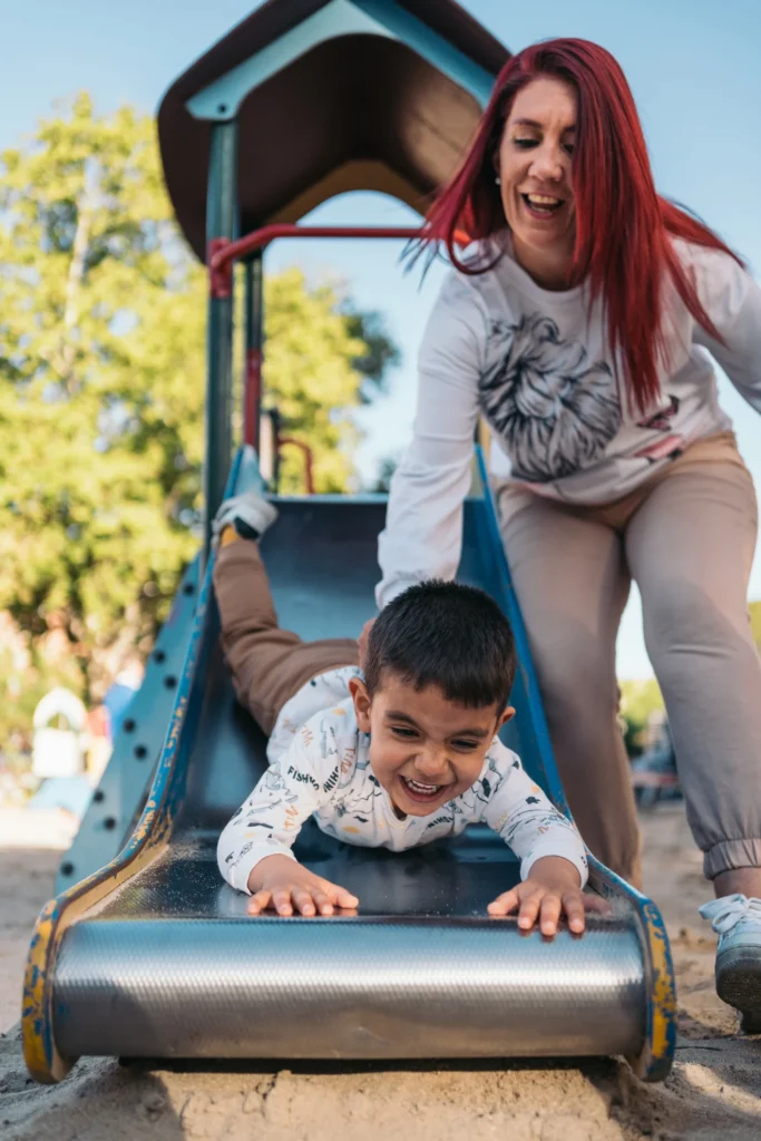 Donate to UPAO page photo of adult helping child on playground slide