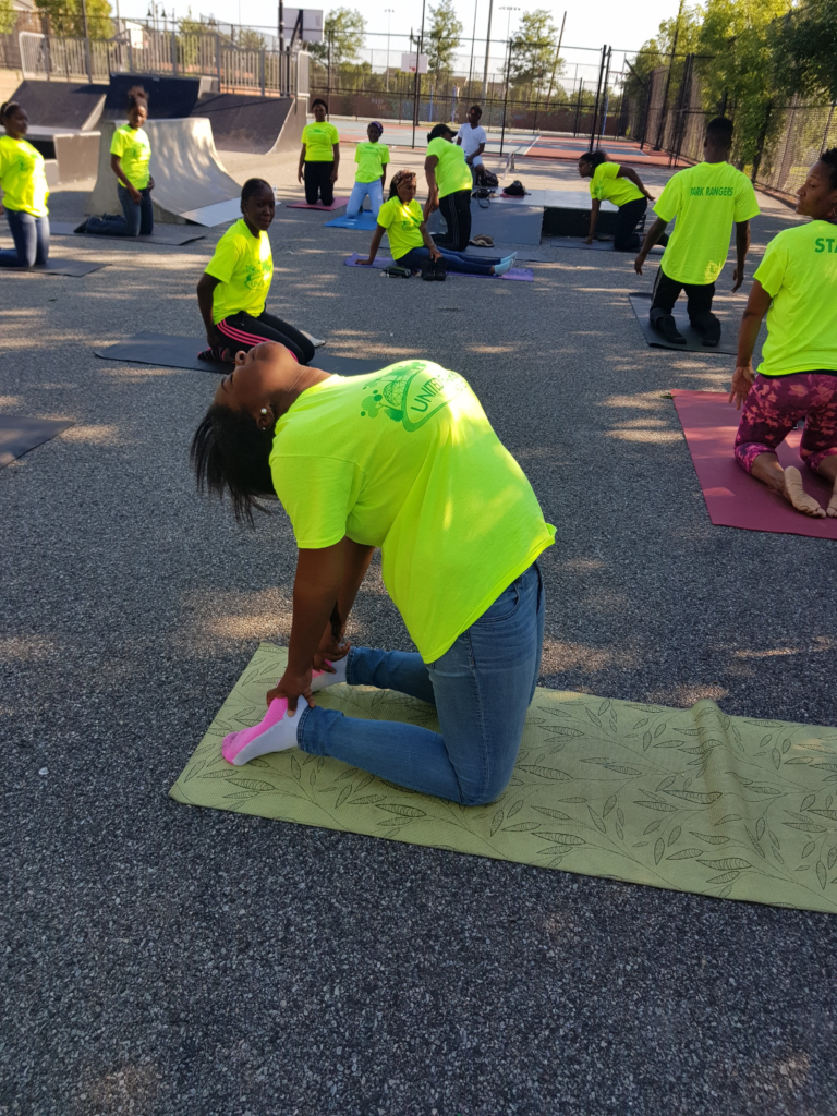 Participants practicing outdoor yoga during a Park Rangers Environmental Enrichment Program wellness activity